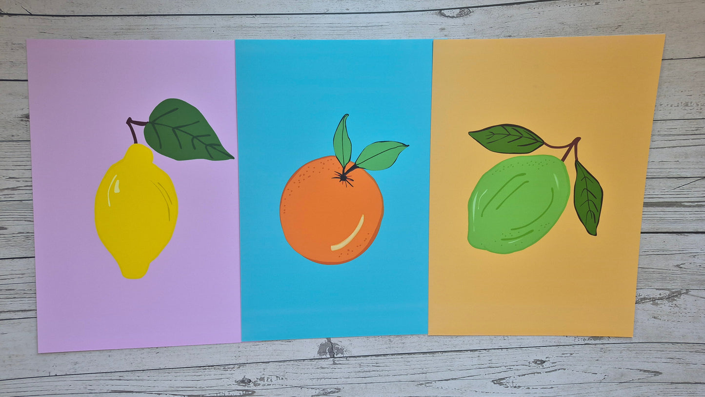 Three colourful art prints featuring lemon, orange, and lime illustrations with solid colourful backgrounds.
