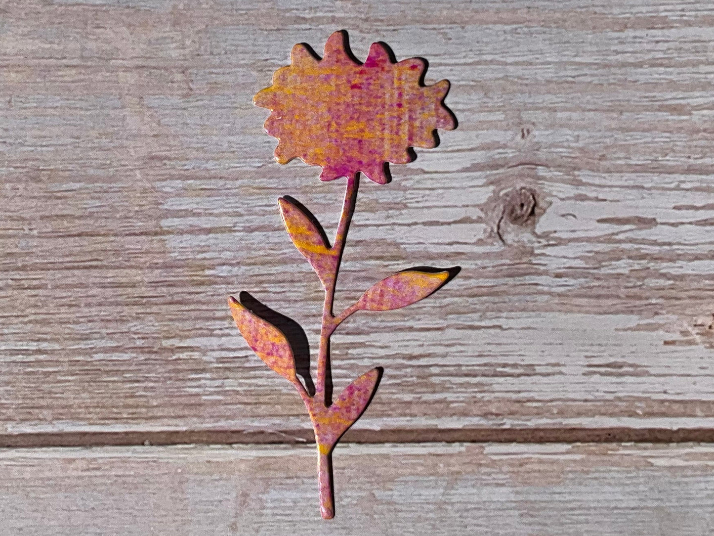 Orange and pink sunset coloured sunflower sticker on a wooden background