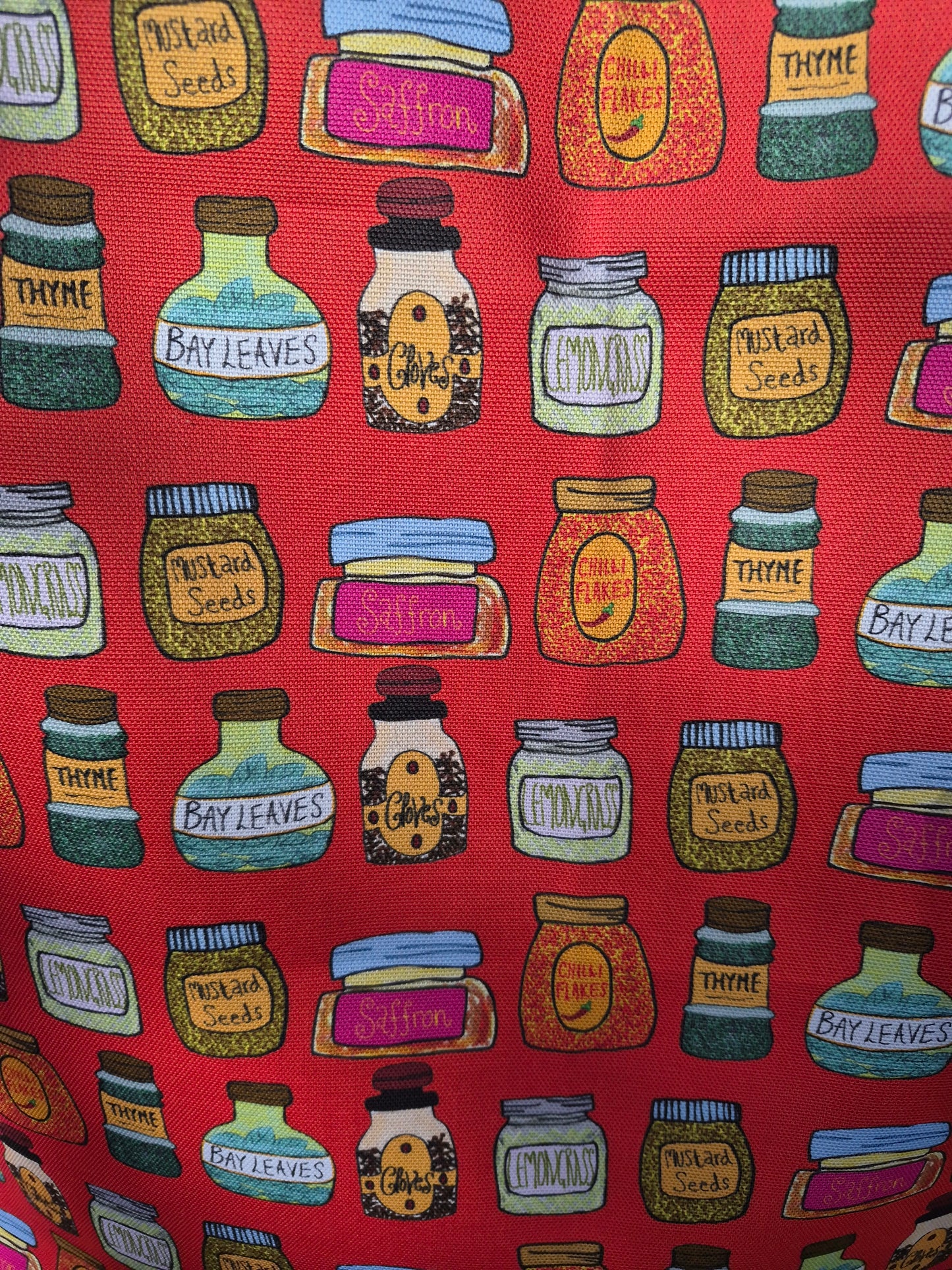 A close up of a spice bottle print on a red organic cotton tea towel