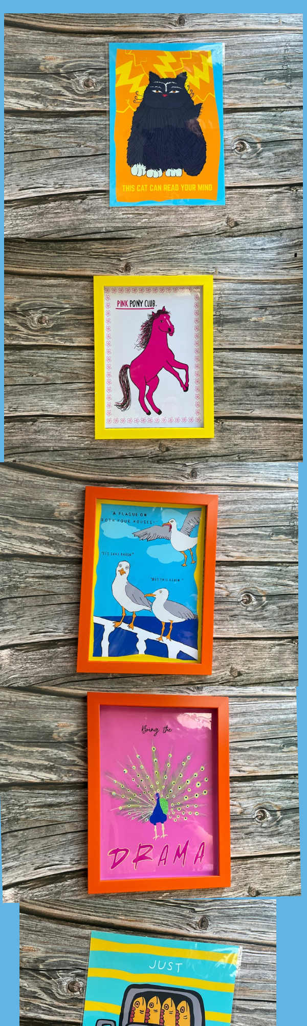 Funny art prints with colourful frames on a wooden surface