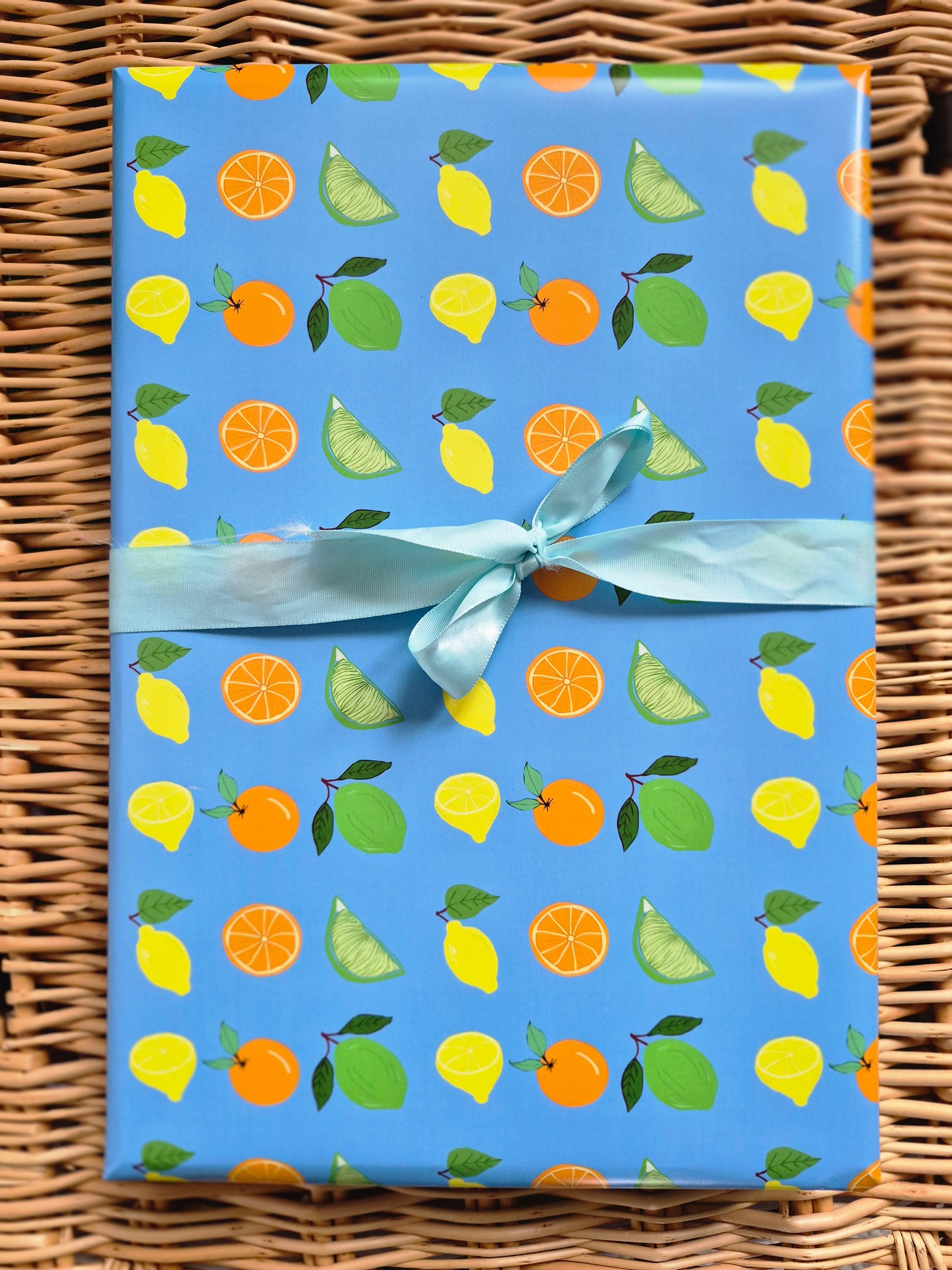 Blue wrapping paper featuring a lemon, lime and orange citrus fruit design