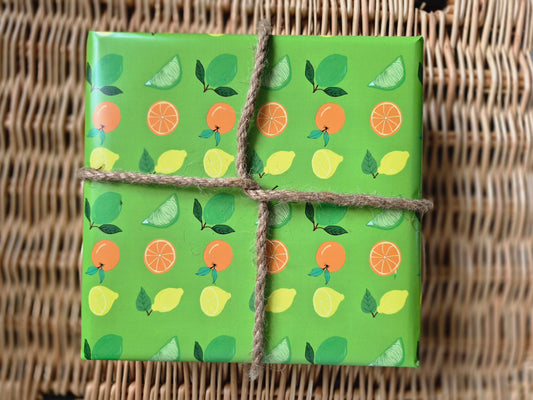 Green wrapping paper featuring a hand-drawn citrus fruit pattern of lemons, limes and oranges