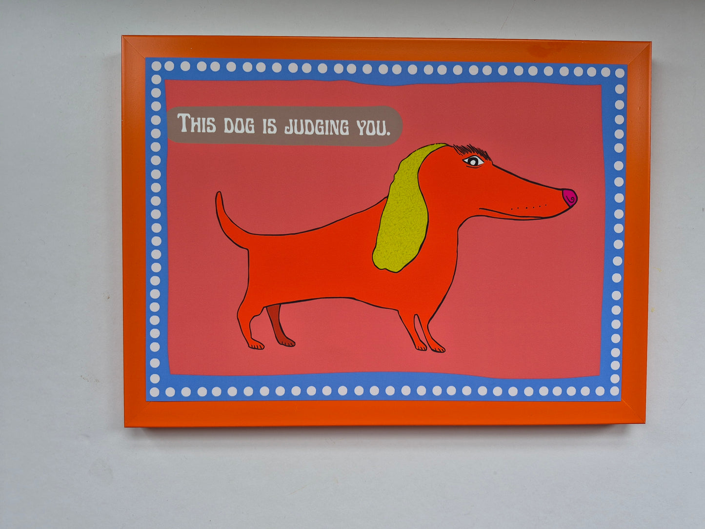 Card with a sausage dog illustration and text 'This dog is judging you.' on a red background