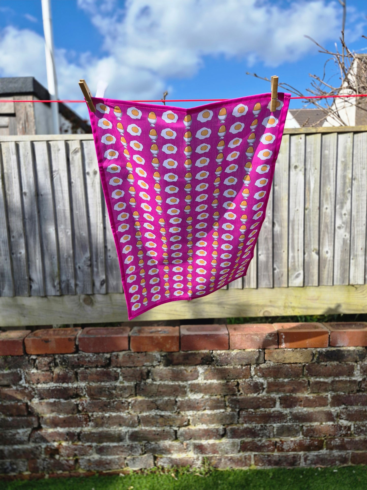 pink printed tea towel hanging on a washing line