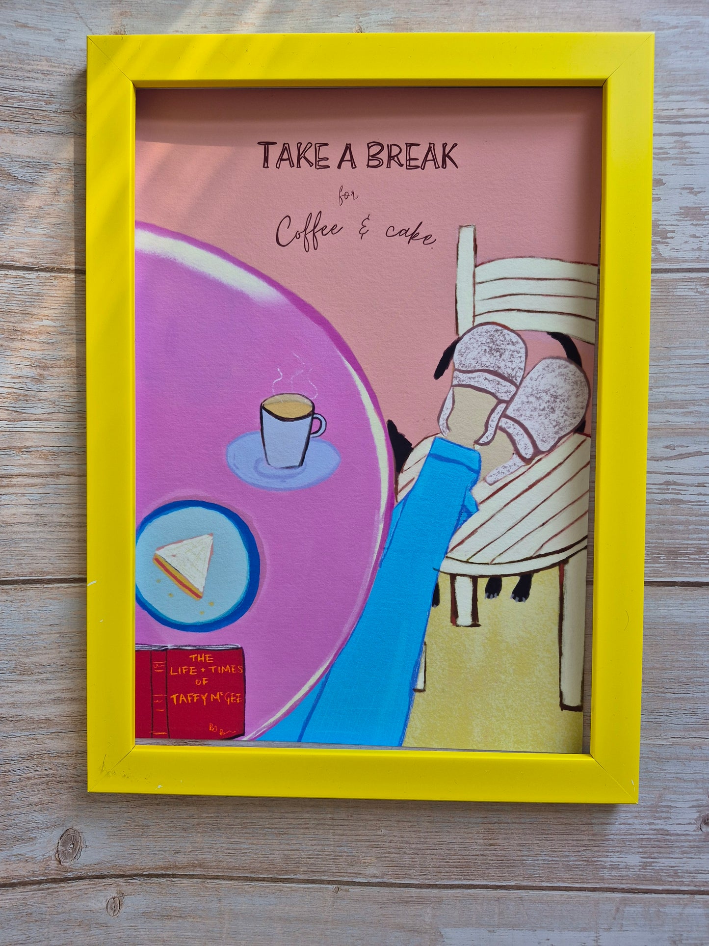 Framed artwork with a person sitting, coffee cup, and text 'Take a Break' on a wooden surface.