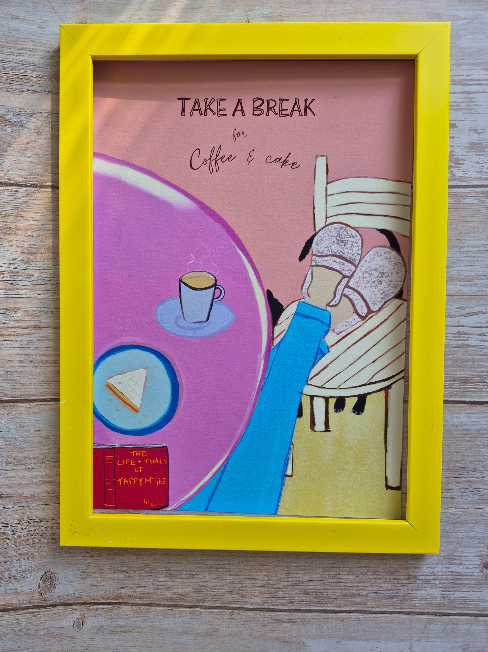 Framed artwork with a person sitting, coffee cup, and text 'Take a Break' on a wooden surface.