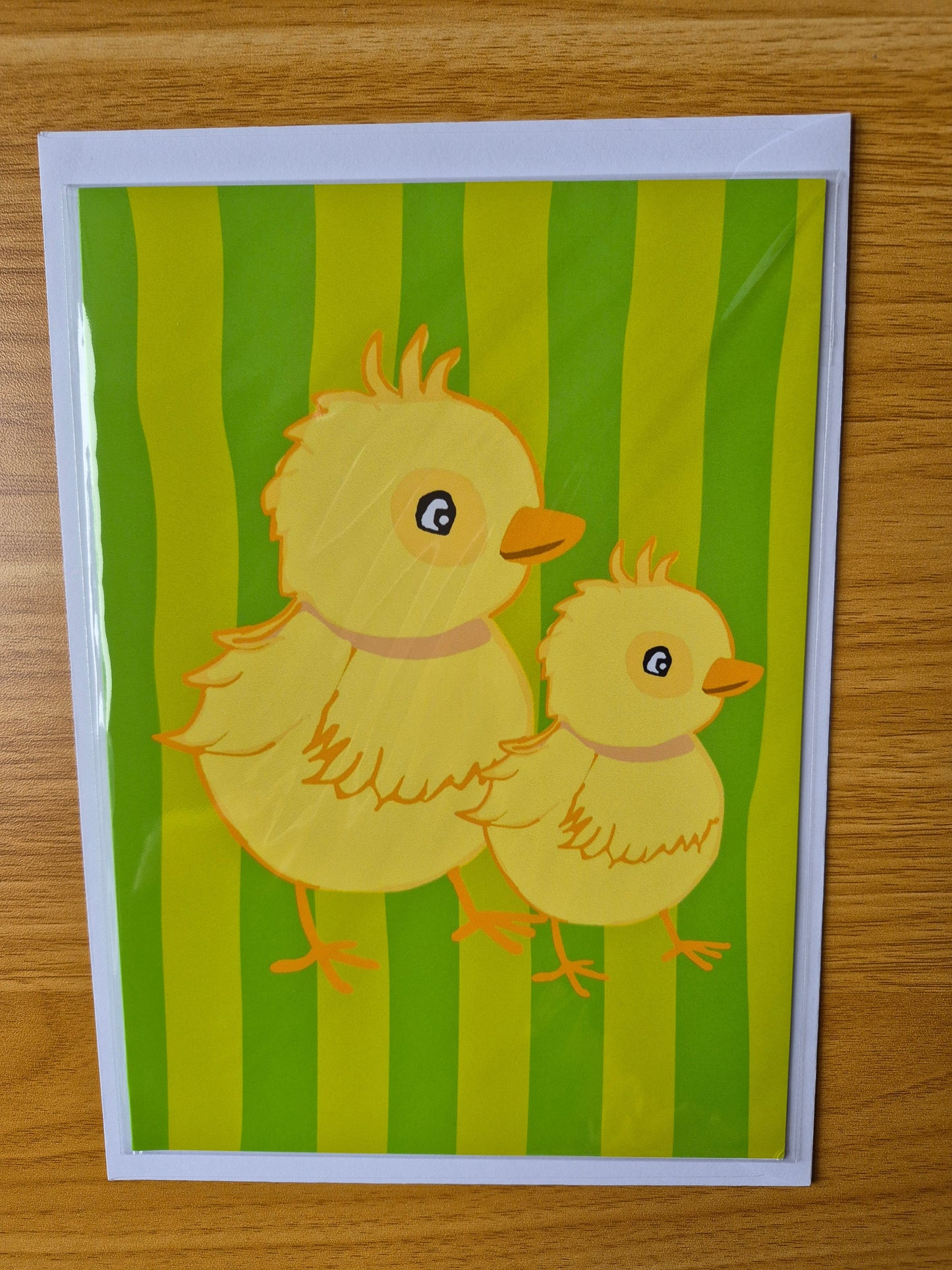Colourful Easter chick greetings card with a green striped background 