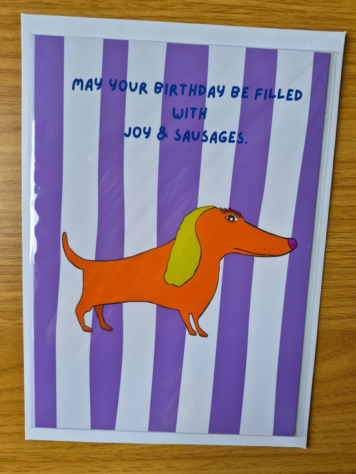 Cartoon sausage dog birthday card on a purple and white striped background with text