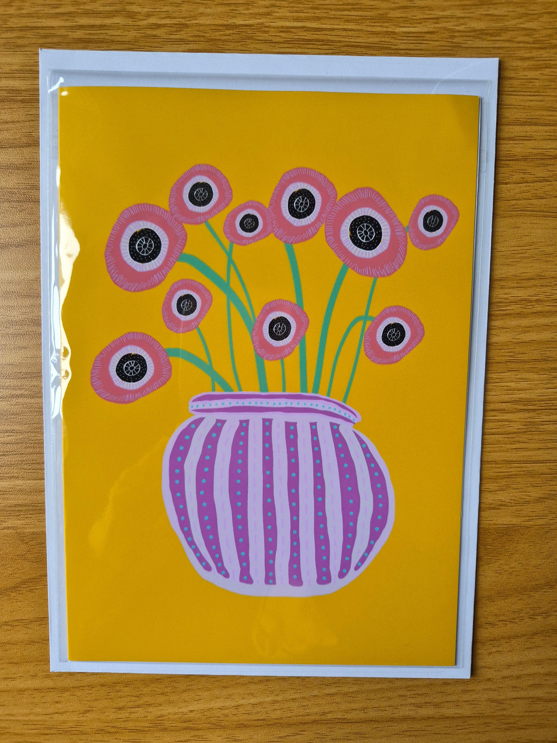 Artistic depiction of colourful flowers in a purple sriped vase on a yellow background
