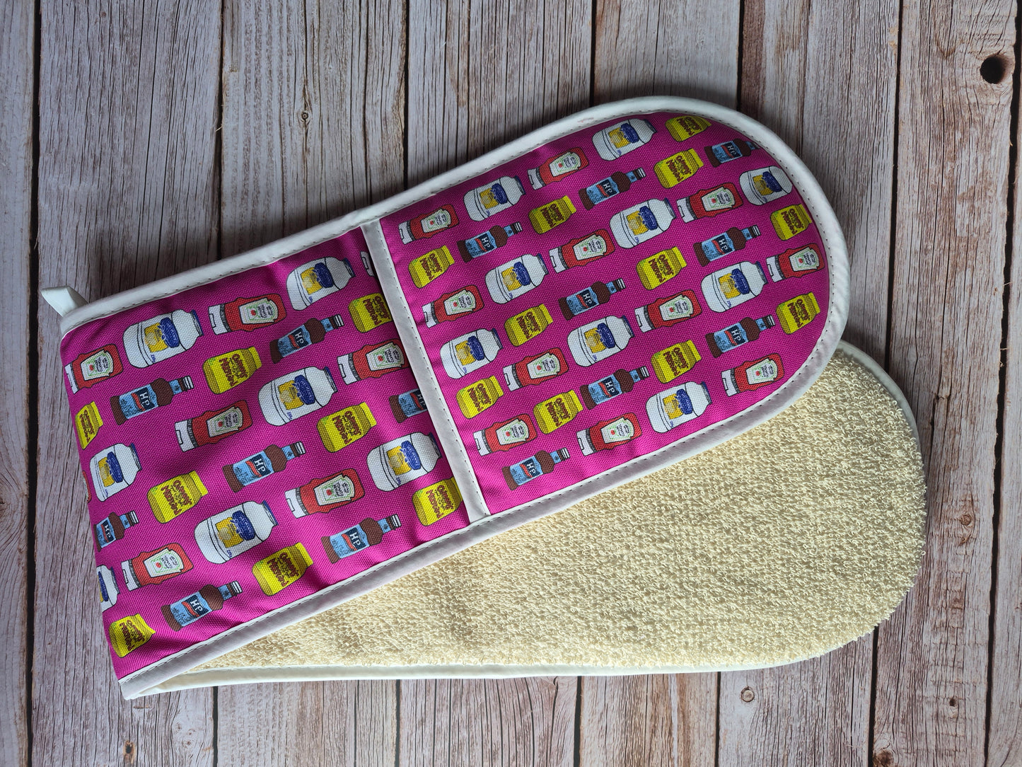 Pink double oven gloves with a ketchup & mustard print.