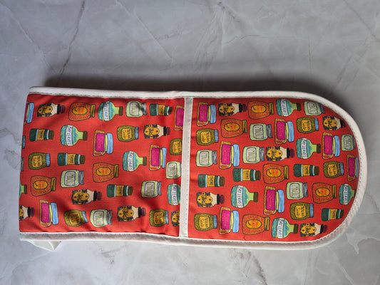 Red oven gloves printed with hand-illustrated spice jars.