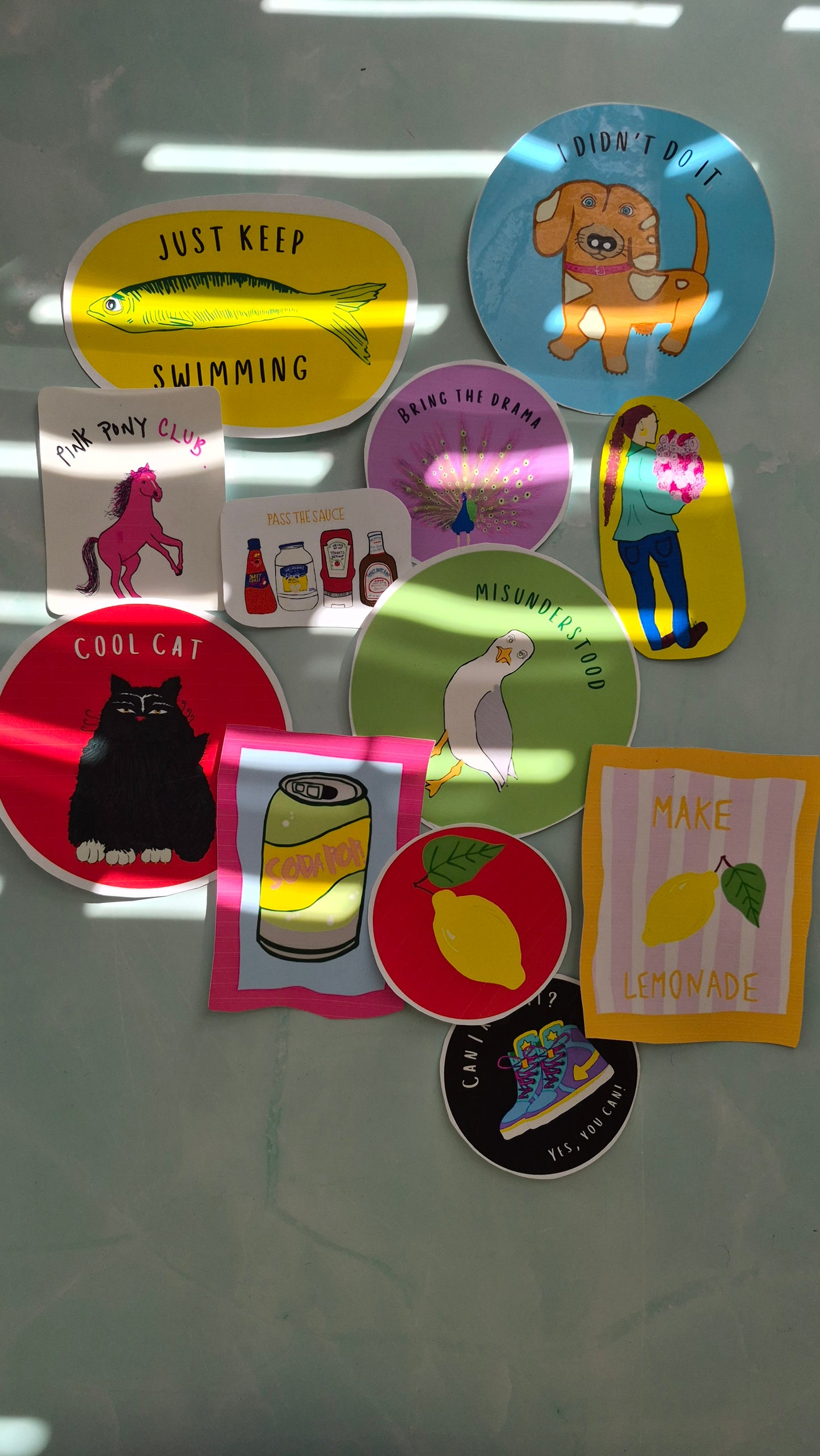 Collection of colourful vinyl stickers in different designs on a light blue marbled background