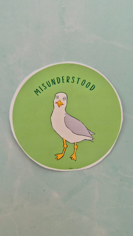Circular vinyl sticker with a seagull illustration and text on a green background