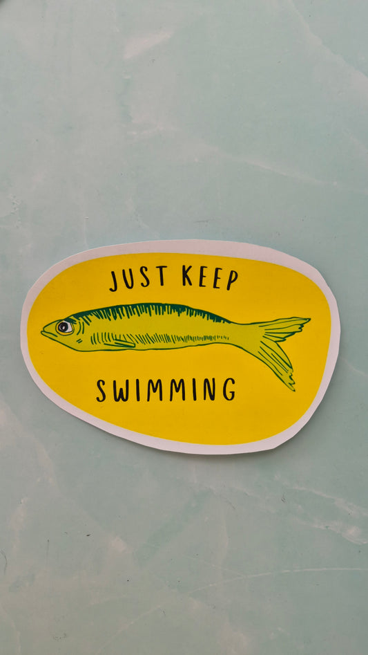 Vinyl sticker with a fish illustration and 'Just Keep Swimming' text on a yellow background