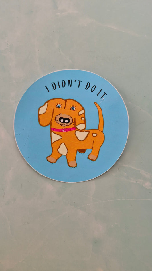 Round vinyl sticker with a cartoon dog and text 'I Didn't Do It' on a blue background