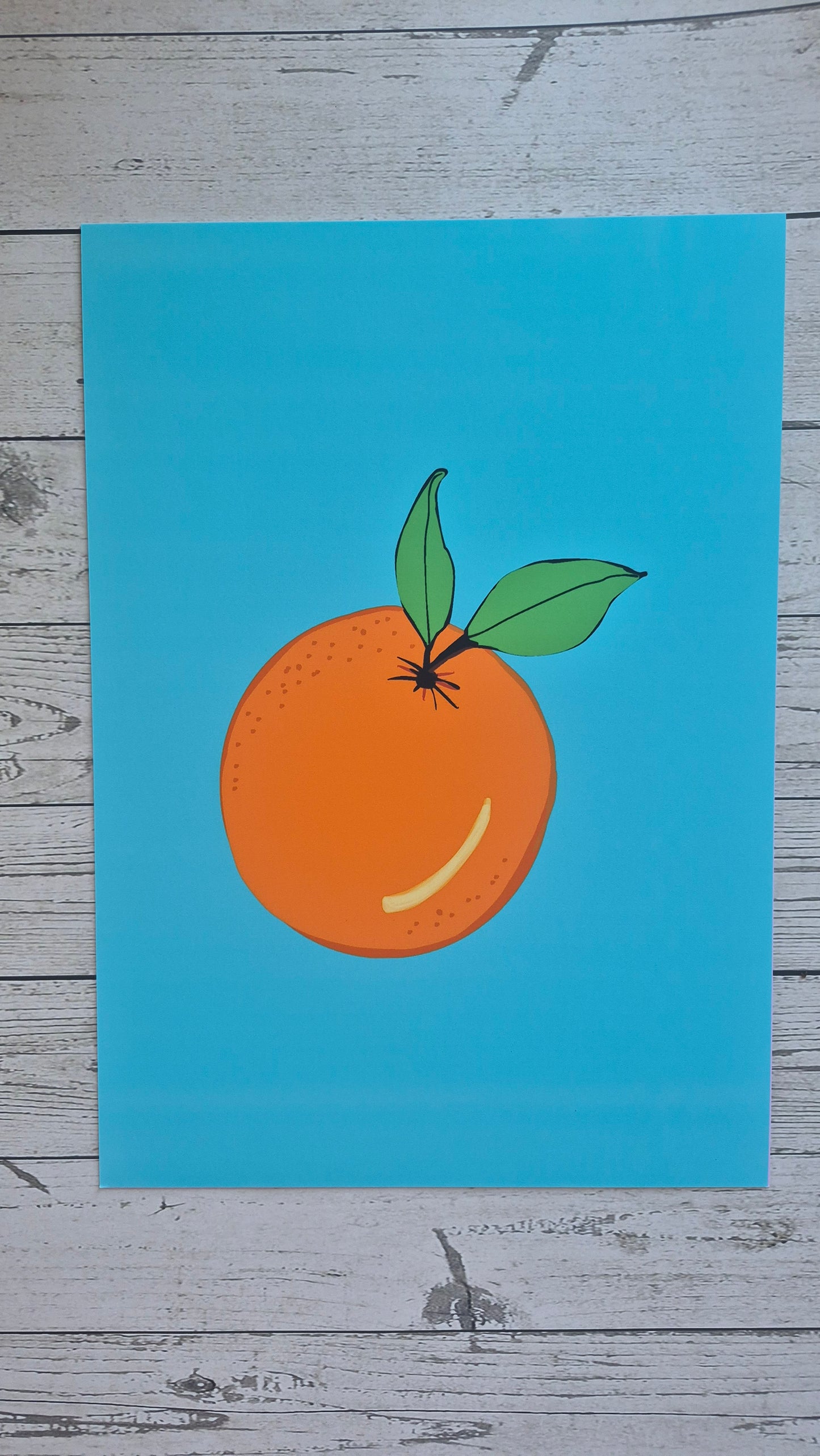 Illustration of an orange with a leaf on a blue background, placed on a wooden surface.