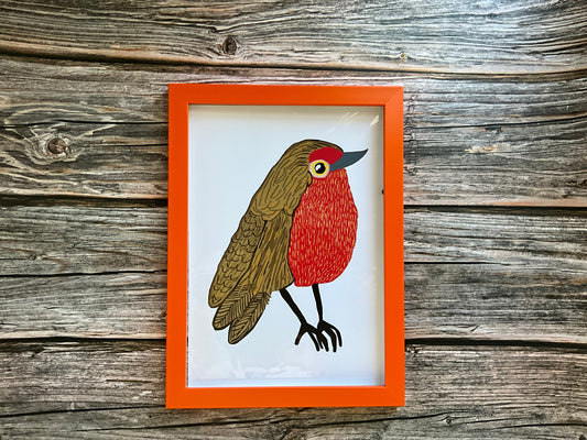 Framed illustration of a Robin on a crisp white background. The frame itself is placed on a wooden background