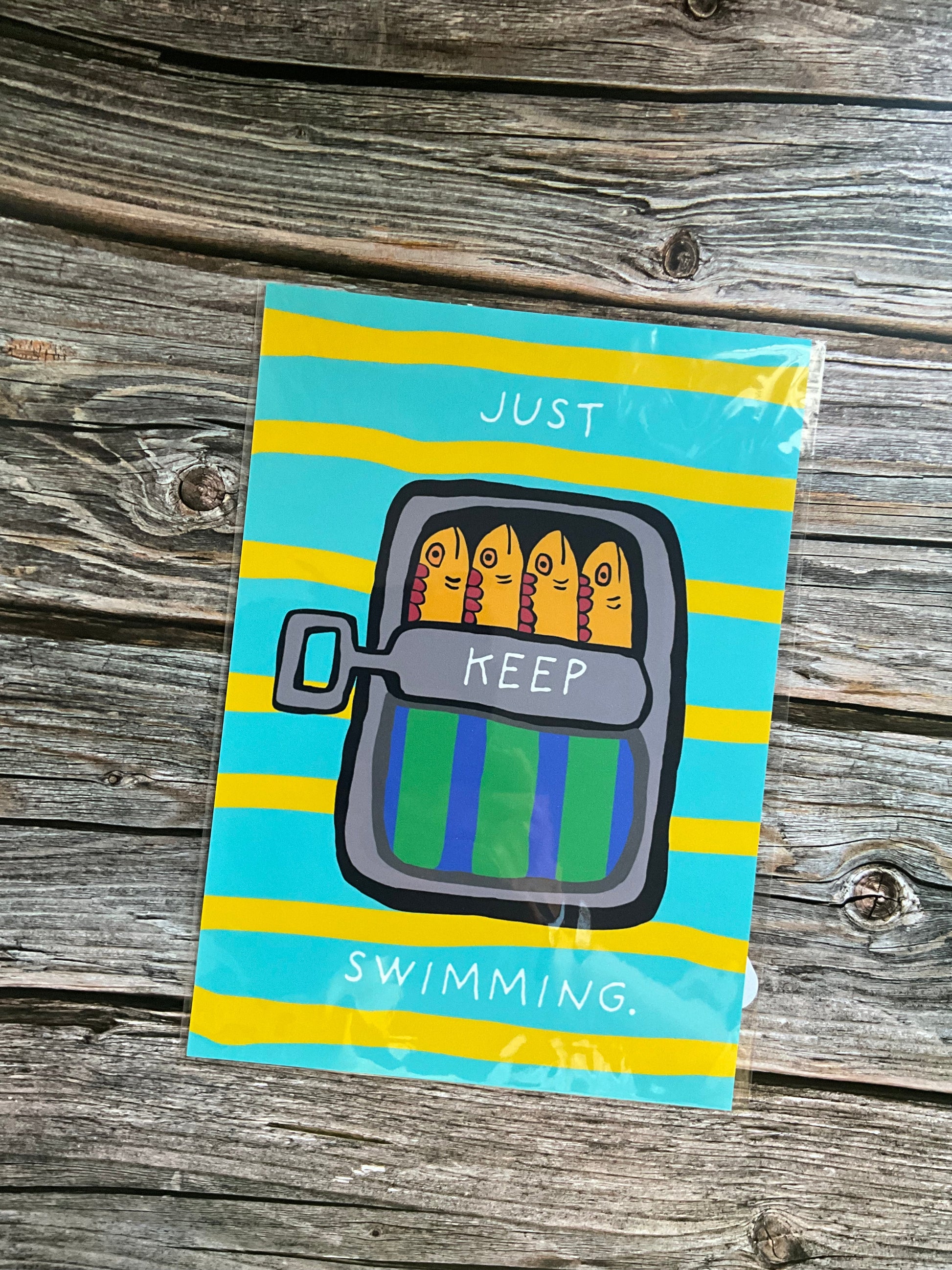 Mackerel wall art print featuring colourful mackerel fish in a green and blue tstriped it in on a yellow and blue striped background. The words ‘Just keep swimming are on the tin’