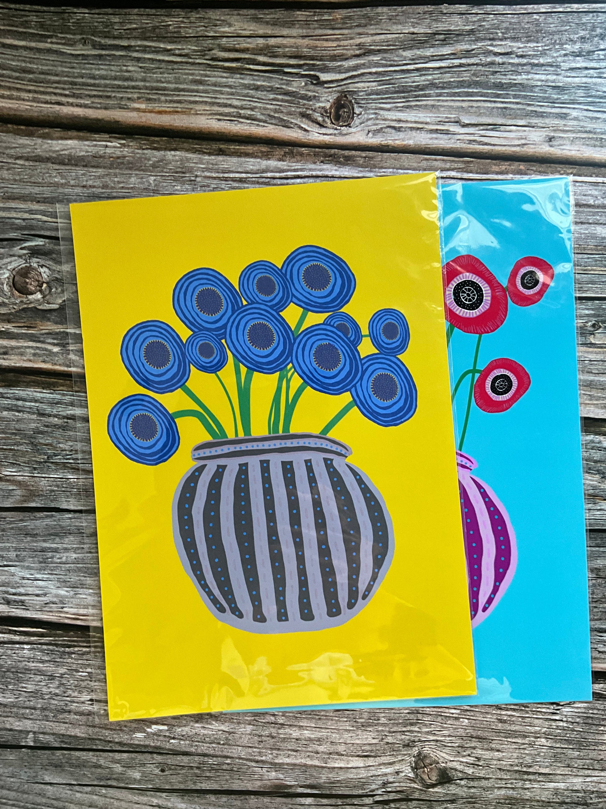 Flower vase illustration with abstract blue poppies in a grey striped vase on a bright yellow background.