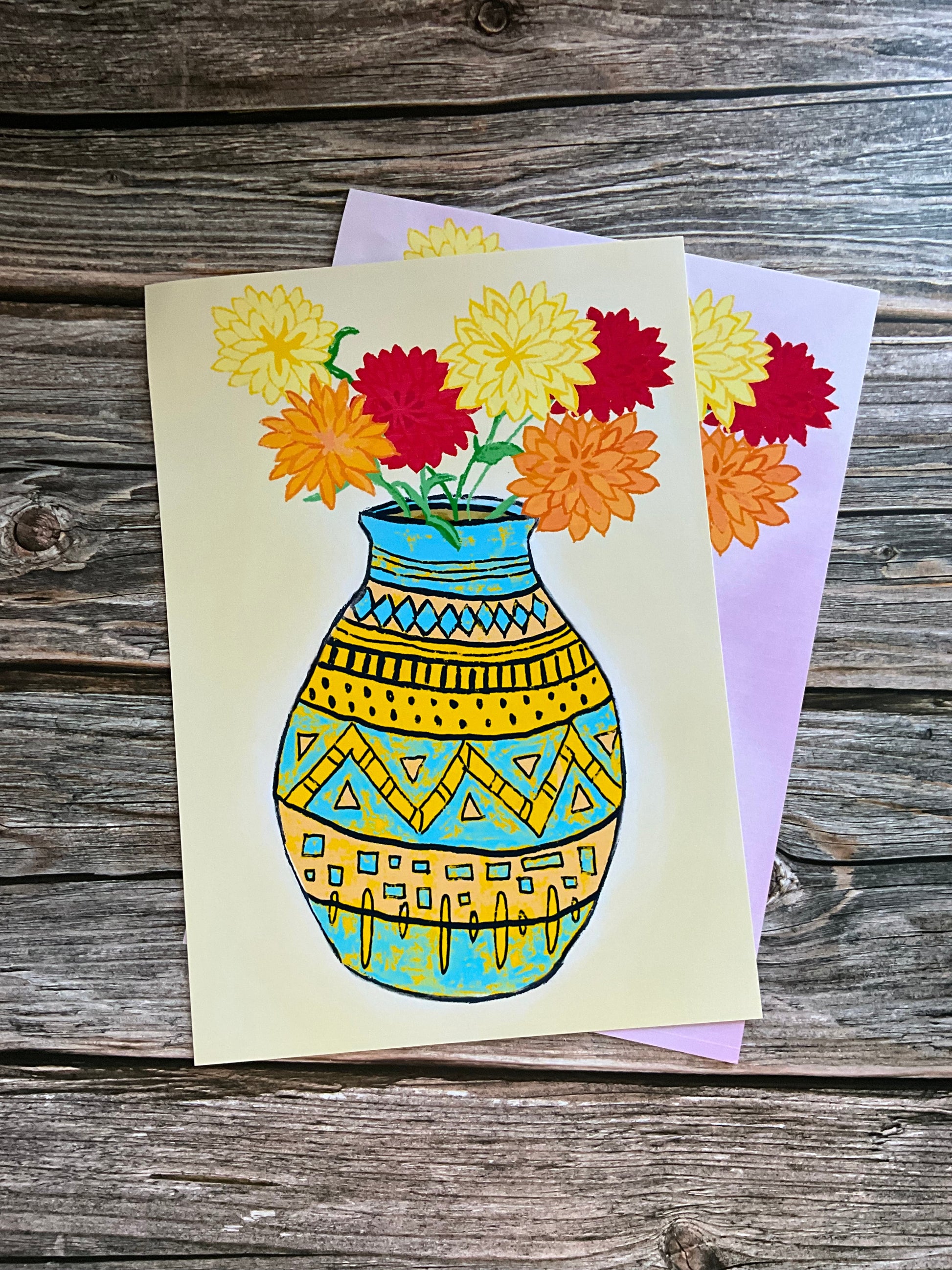Card with a colorful vase and flowers design on a wooden surface
