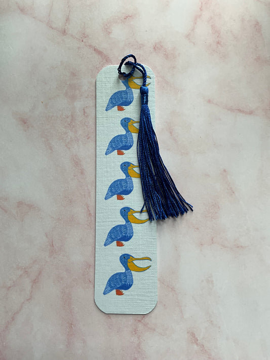 Pelican print bookmark with blue tassel on a pink marble background