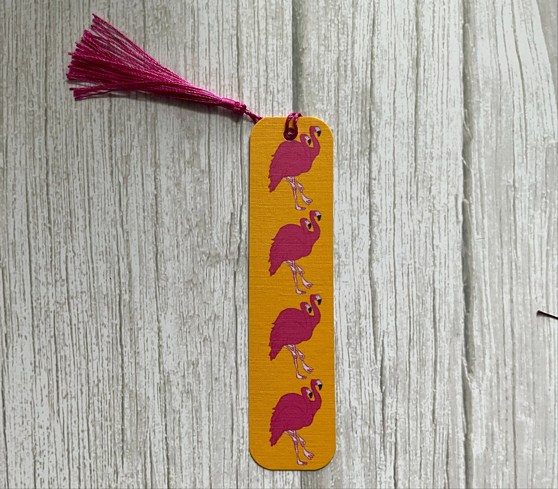 Pink flamingo bookmark featuring a flamingo print on an orange background. 