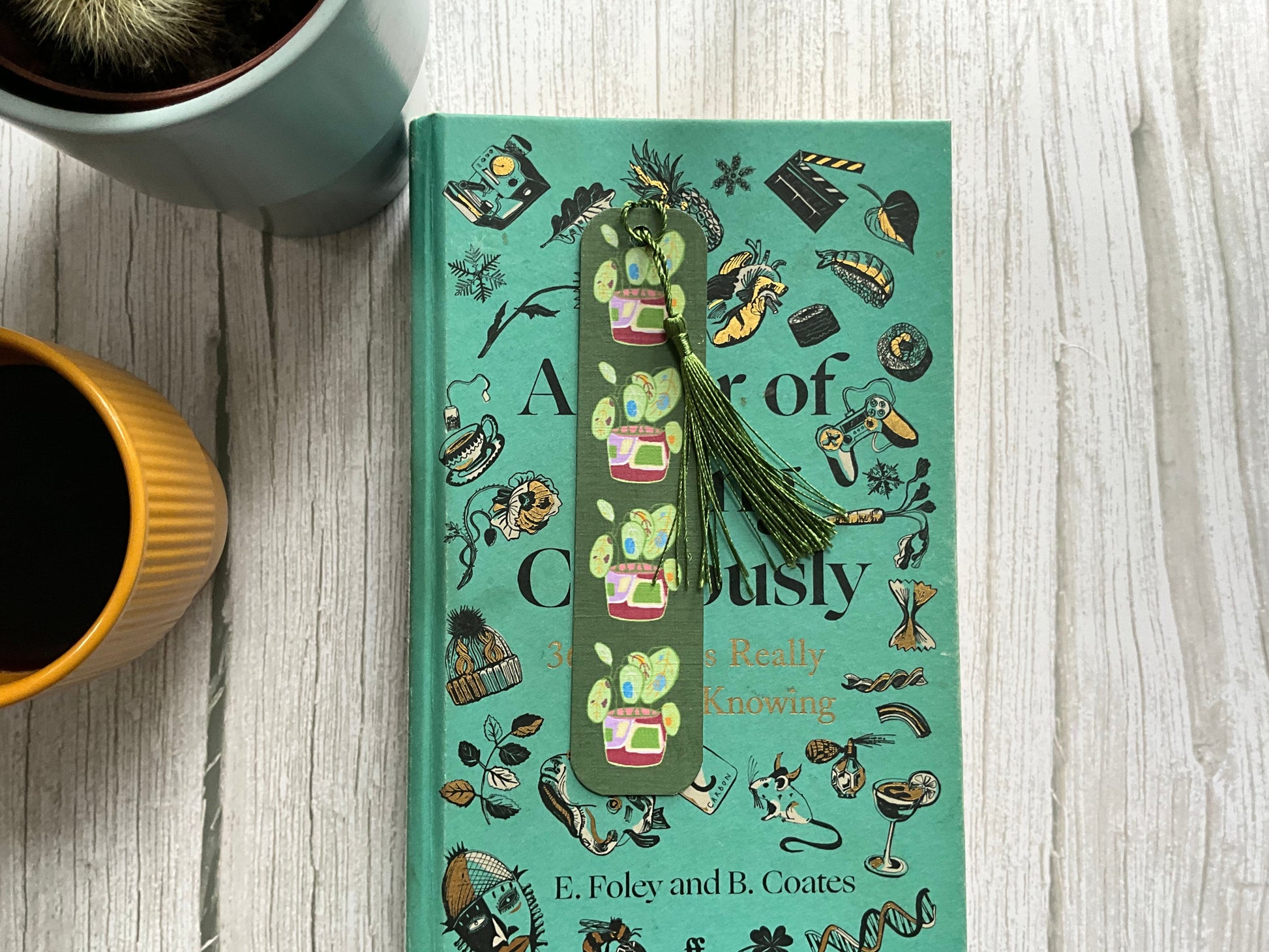 Decorative book with a pot plant printed bookmark on a wooden surface