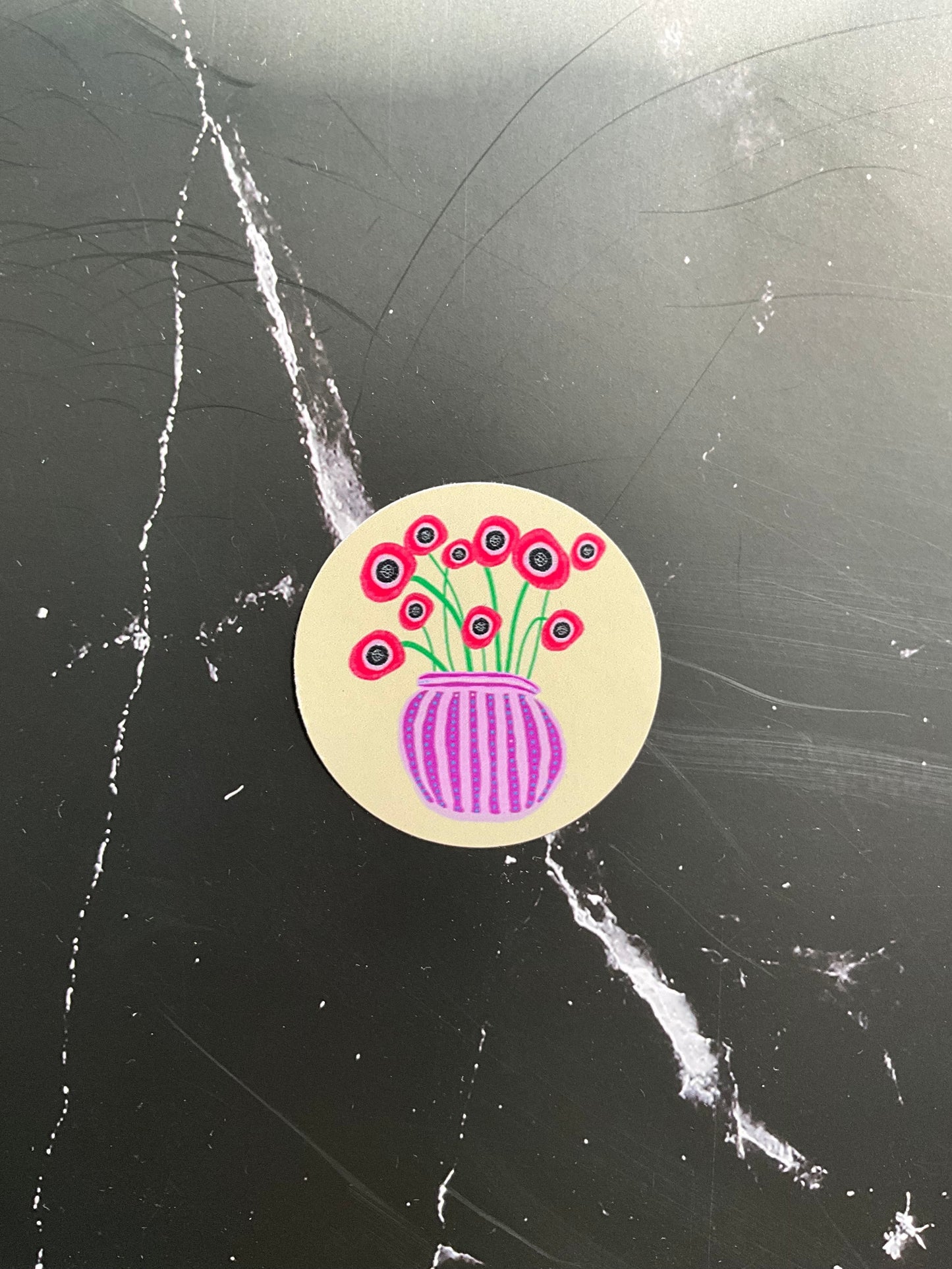 Cream circle vinyl sticker featuring a colourful vase of red poppies.
