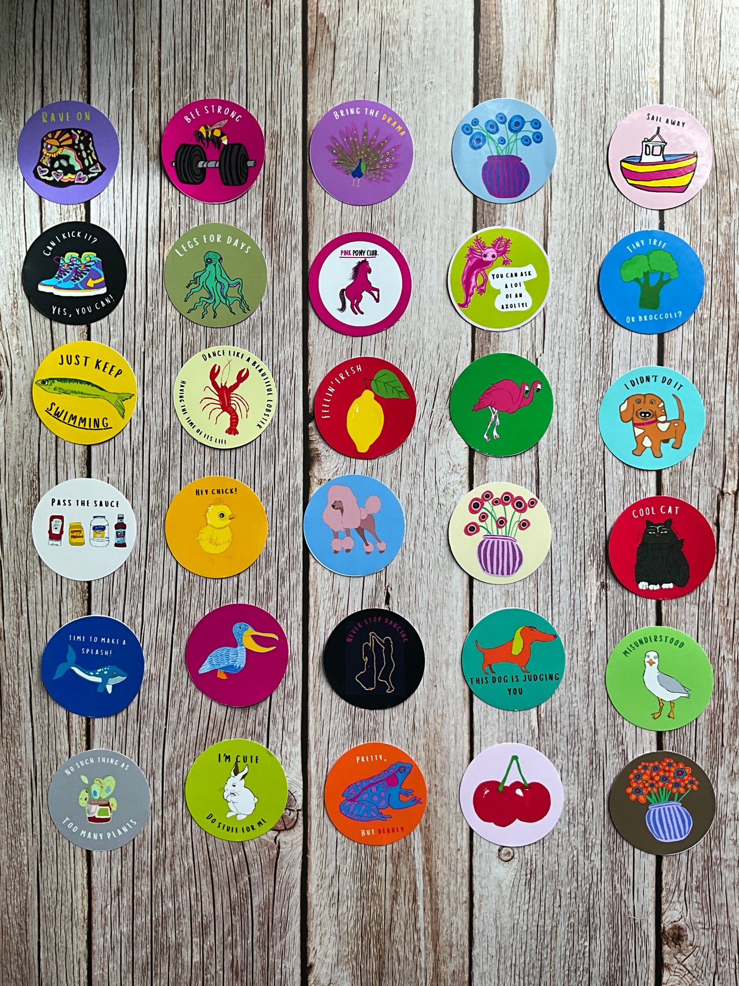 Collection of colorful circular stickers on a wooden surface