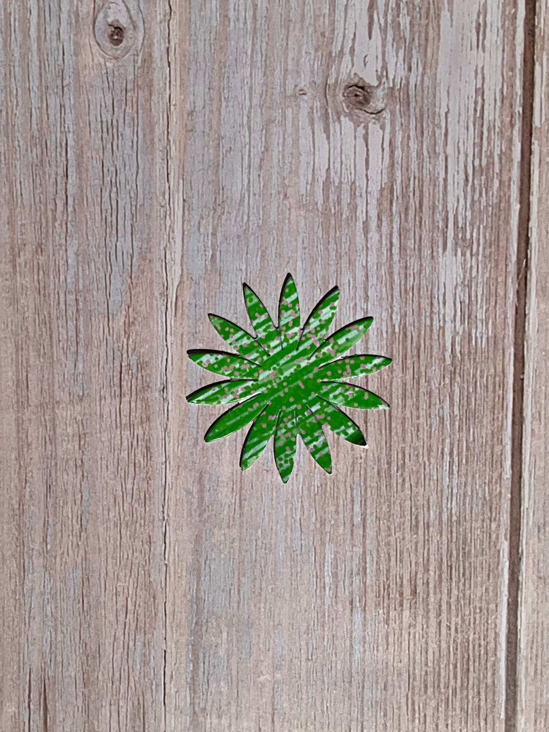 Green and white patterned flower vinyl sticker on a wooden table