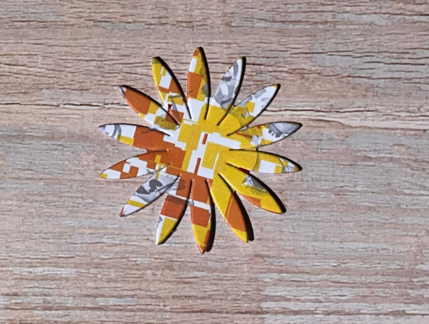 Orange, yellow and white patterned floral vinyl sticker on a wooden background
