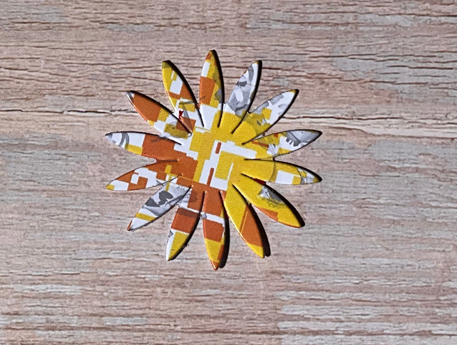 Orange, yellow and white patterned floral vinyl sticker on a wooden background