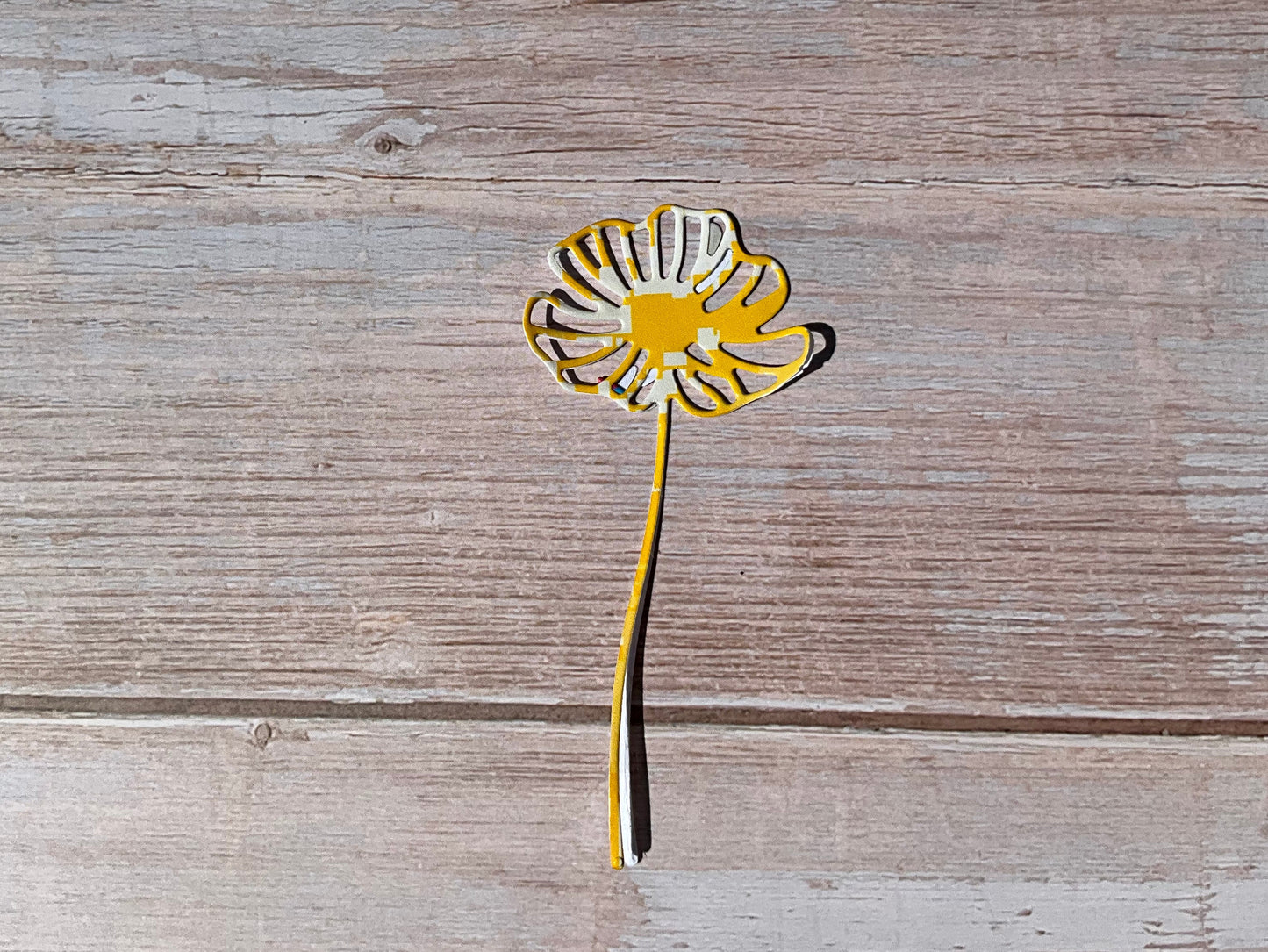 Yellow daisy flower sticker on a wooden table