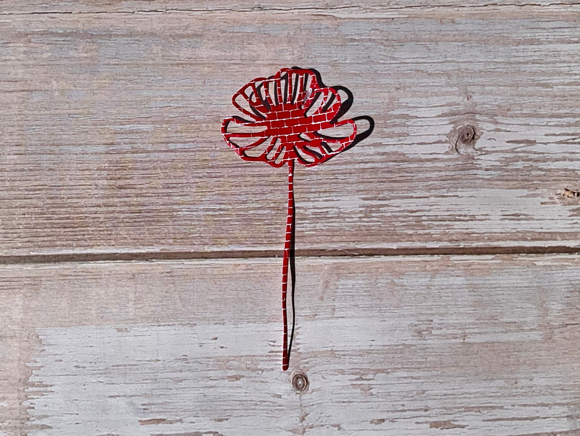 Red and white pattern sticker in the shape of a flower on a wooden table