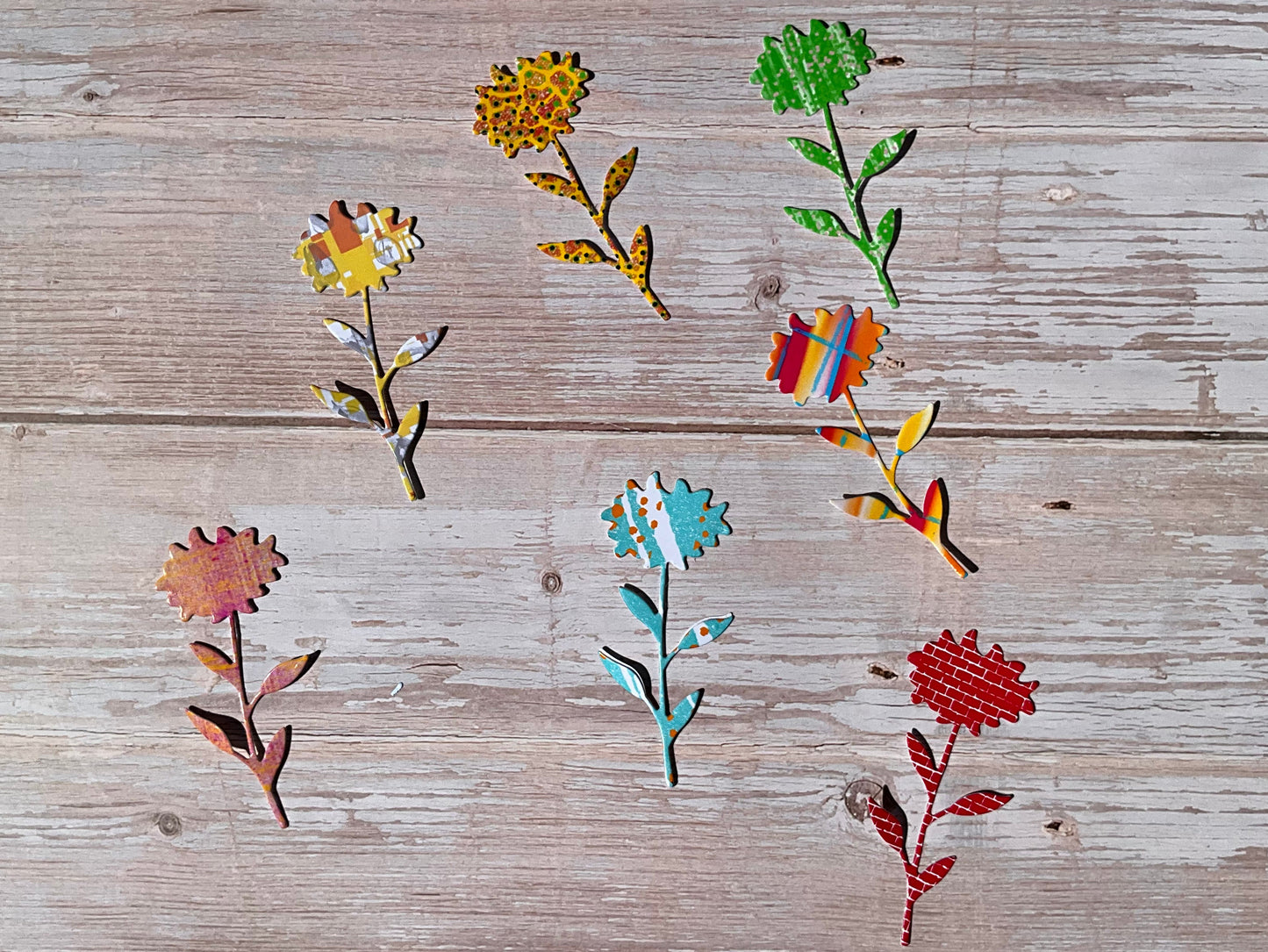 Colourful sunflower shaped vinyl stickers in different colours and patterns on a wooden table