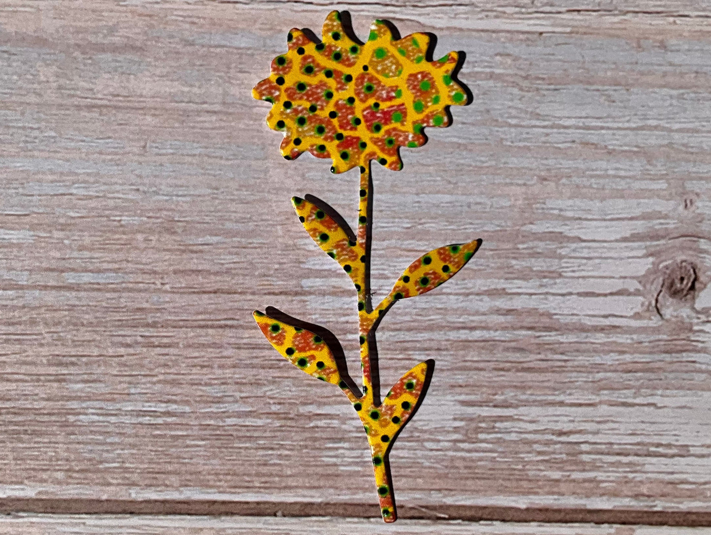 Yellow sunflower shaped sticker on a wooden bacground