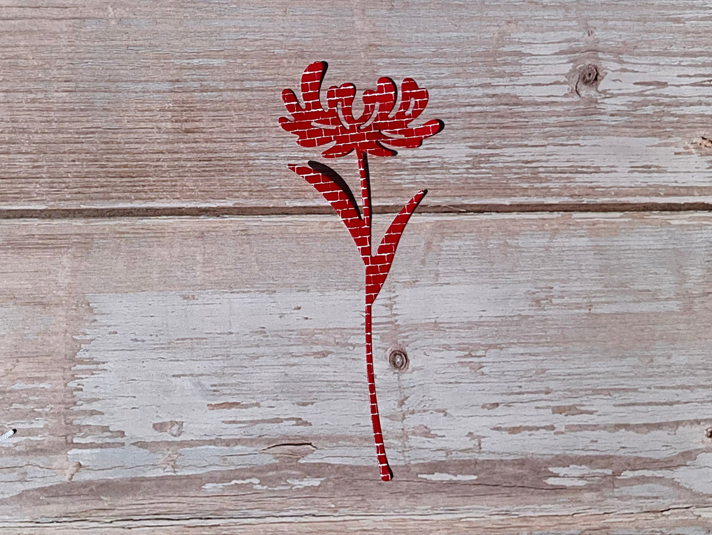 Red floral sticker design on a wooden surface