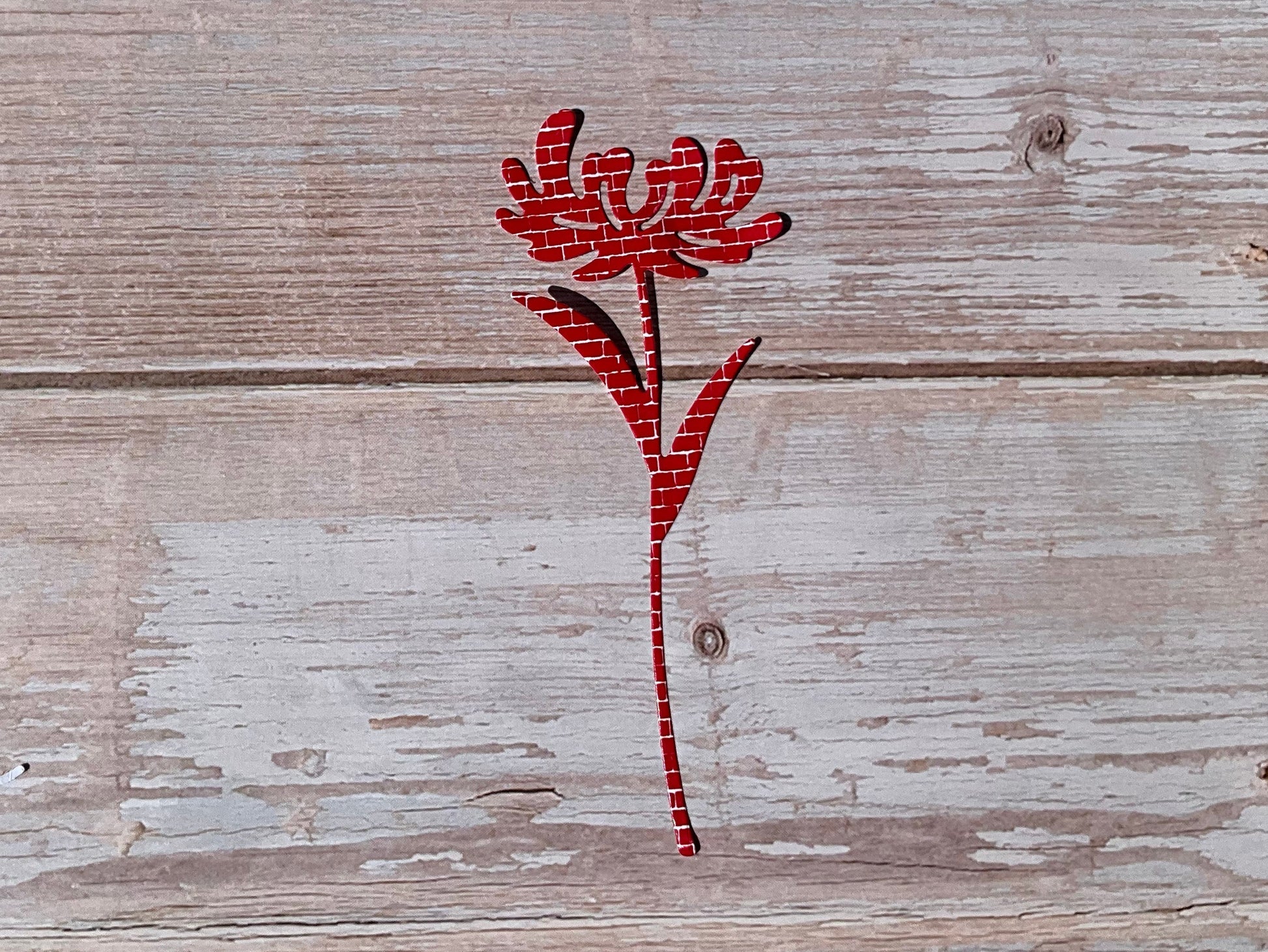 Red floral sticker design on a wooden surface