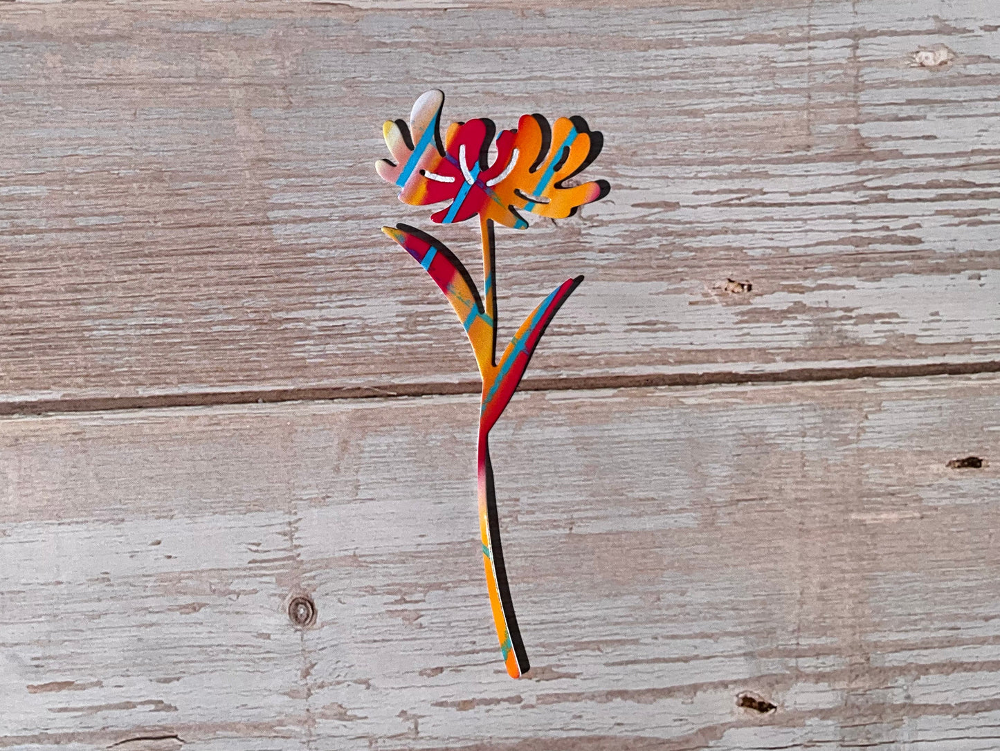 Red, orange, pink and blue die cut vinyl sticker in the shape of a dandelion flower