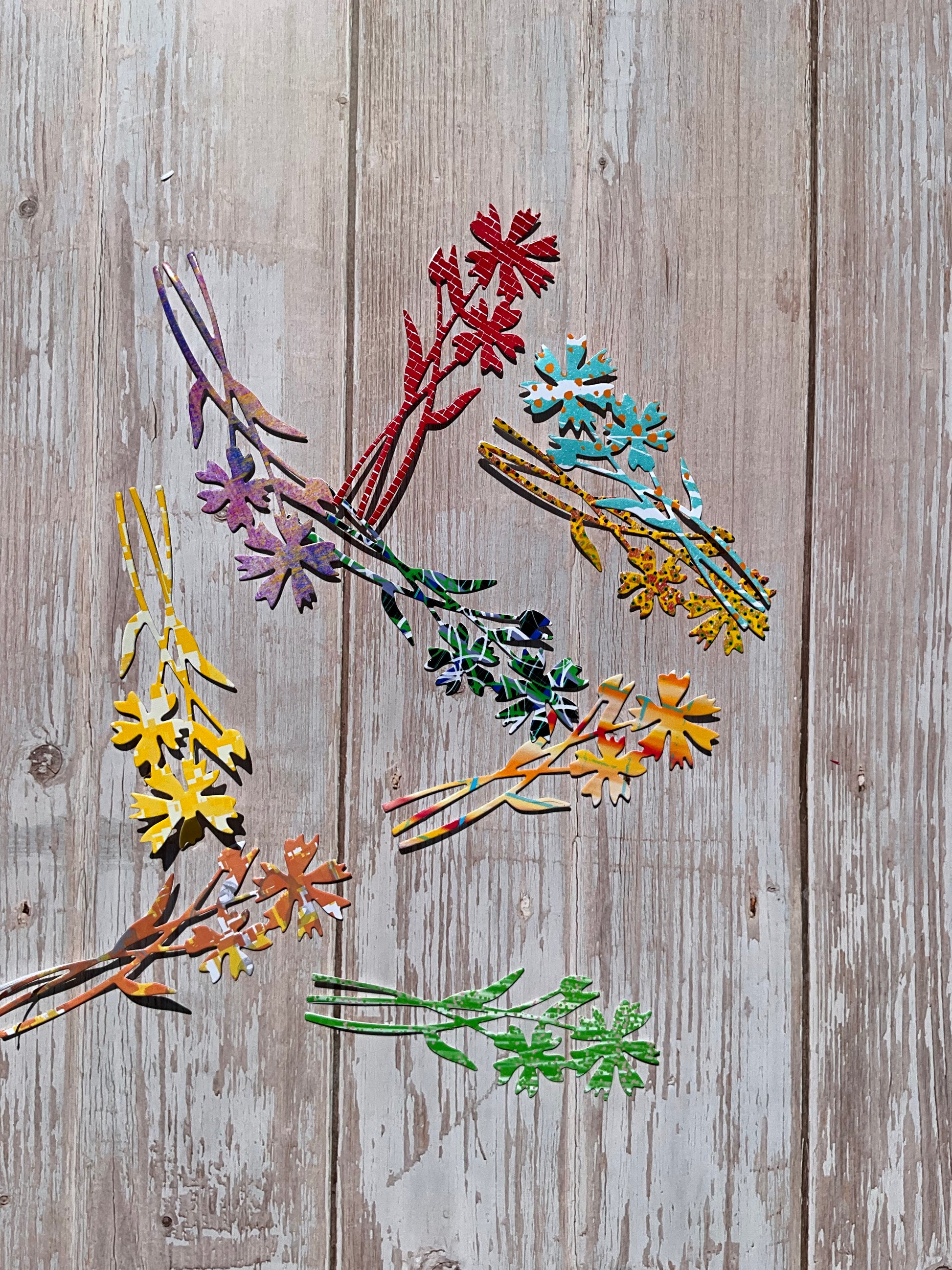 Colorful floral cutout stickers on a wooden surface
