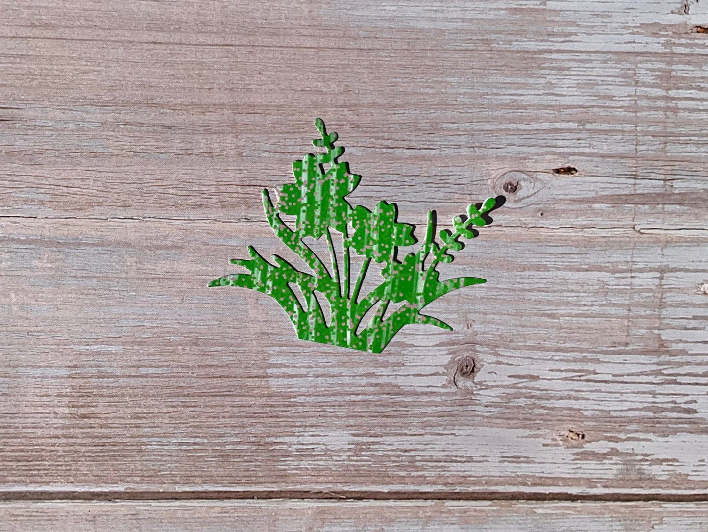 Green flower outline sticker on a wooden surface