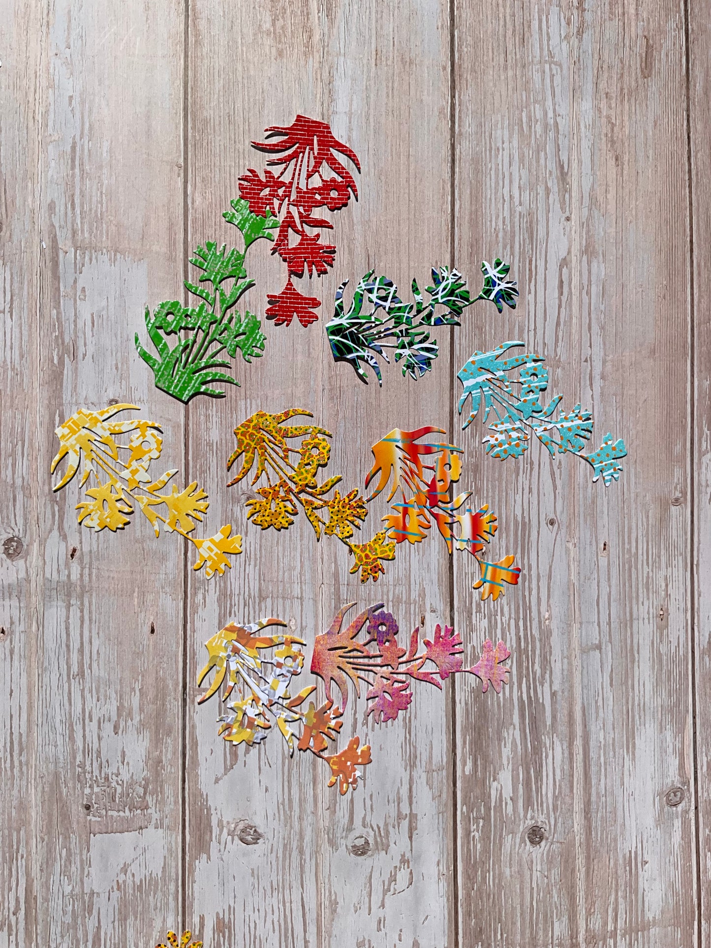 Colourful  floral sticker cutouts on a wooden surface