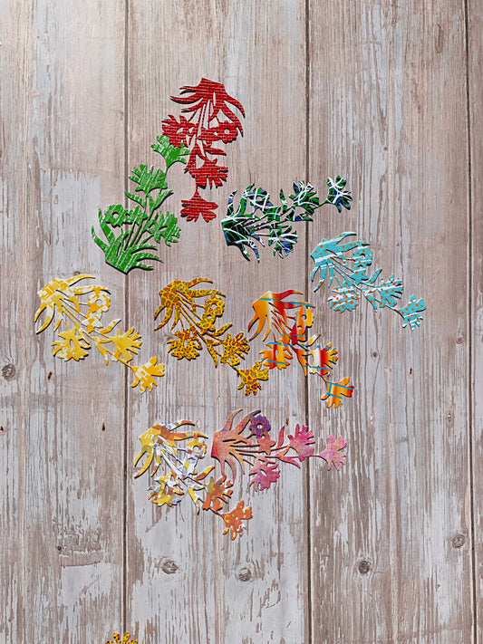 Colourful  floral sticker cutouts on a wooden surface