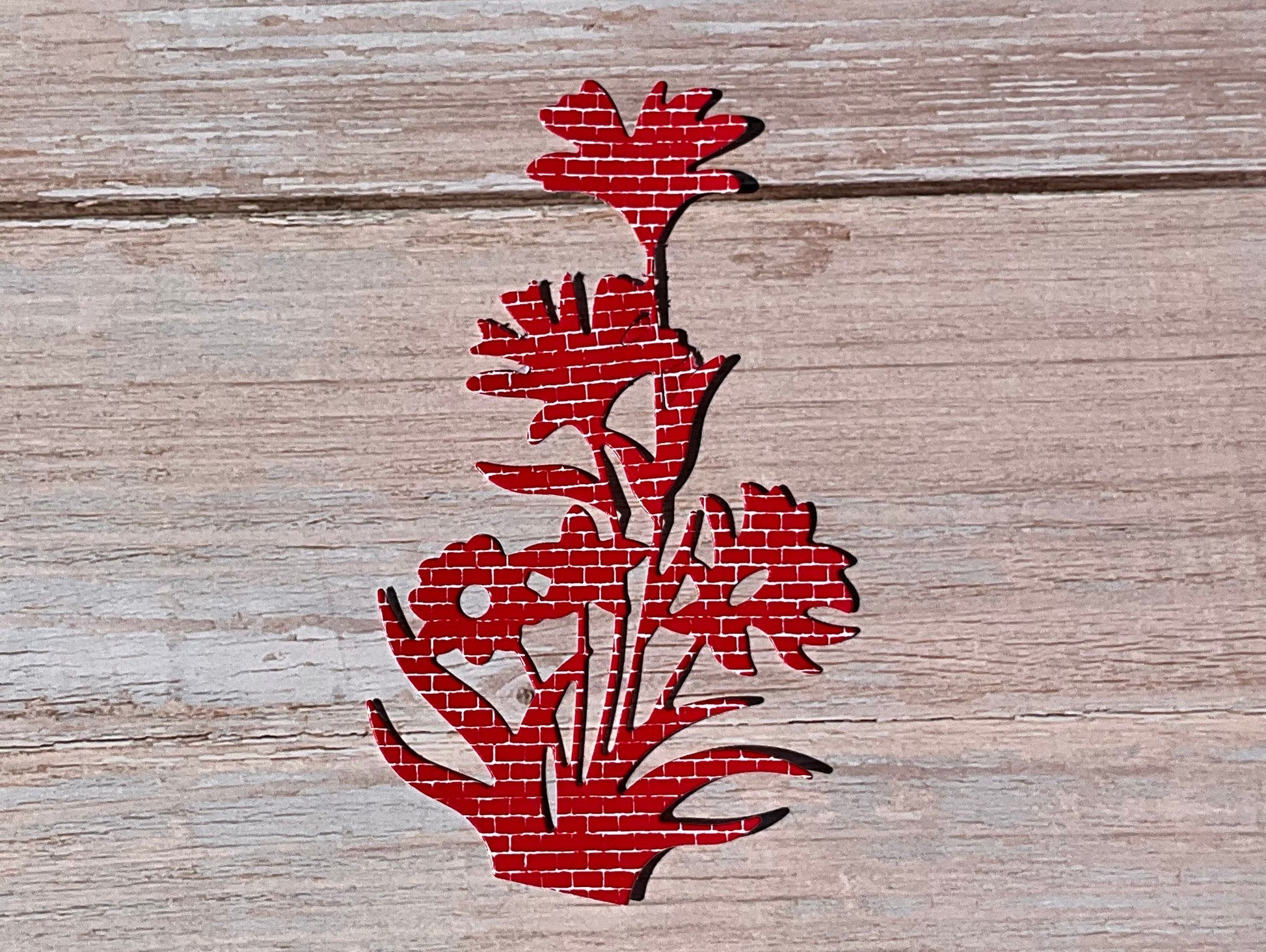 Red floral design vinyl sticker on a wooden surface