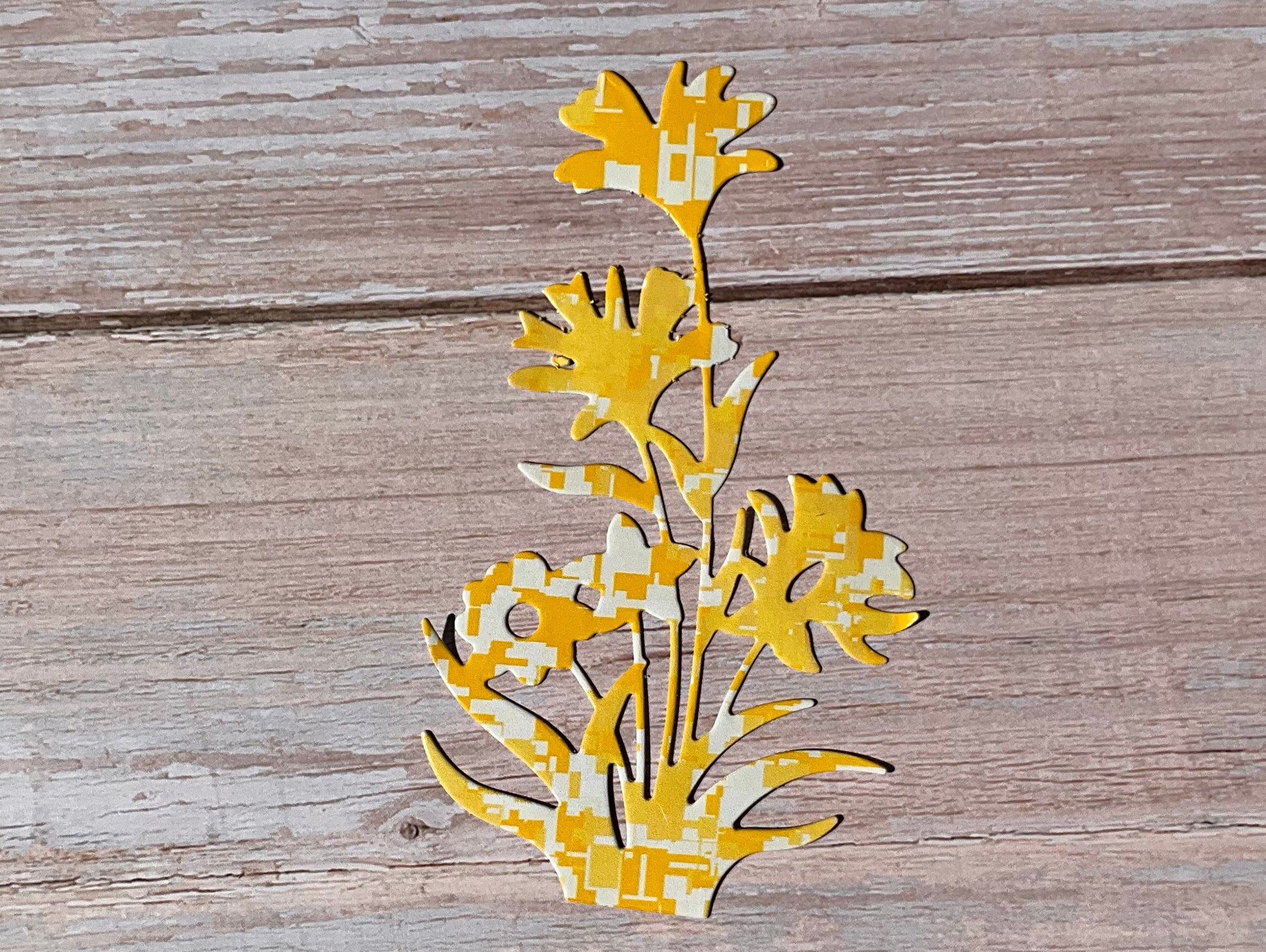 Decorative yellow floral vinyl sticker on a wooden surface