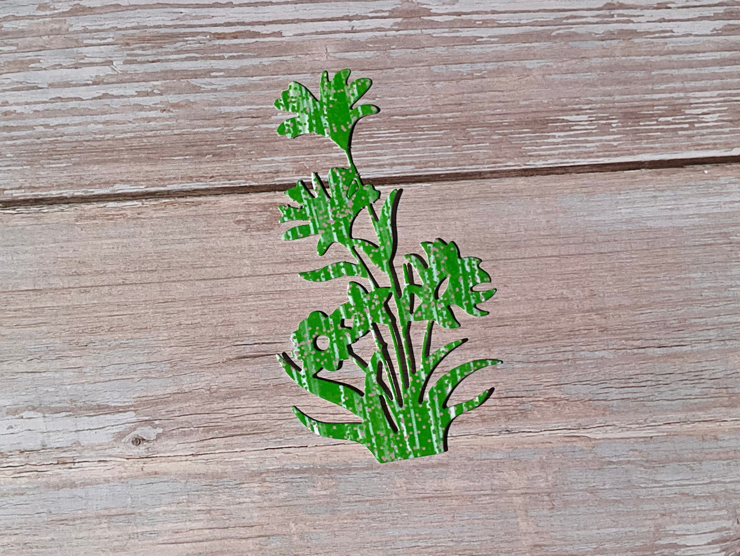 Green and white patterned plant vinyl sticker on a wooden surface