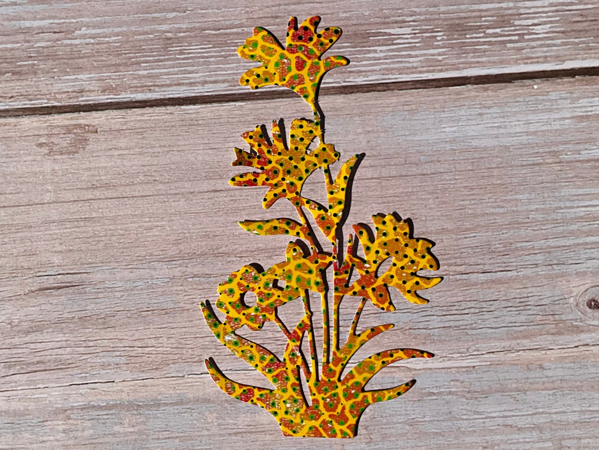 Yellow and orange patterned flower vinyl sticker on a wooden table