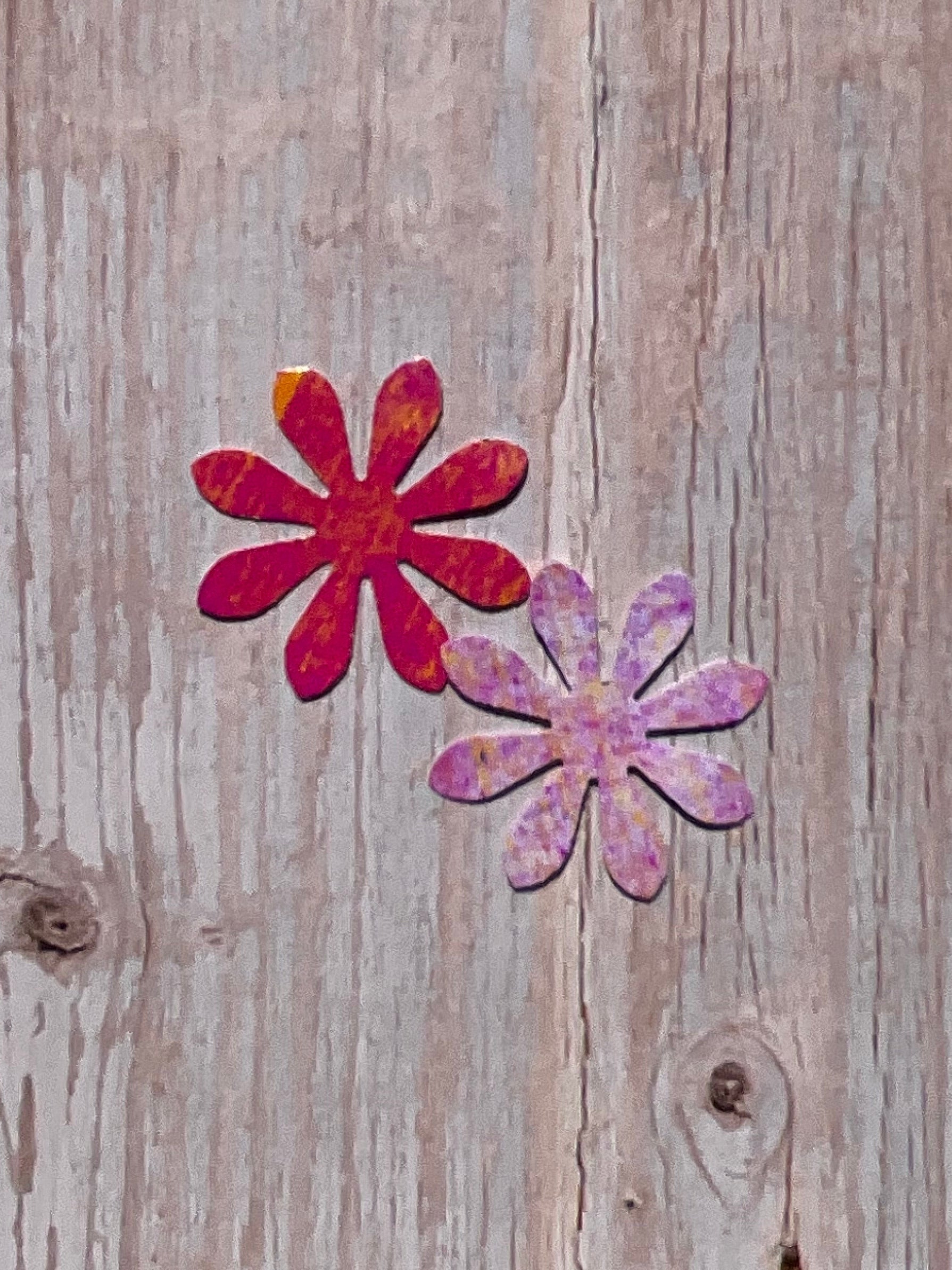 Pink daisy shaped vinyl stickers on wood