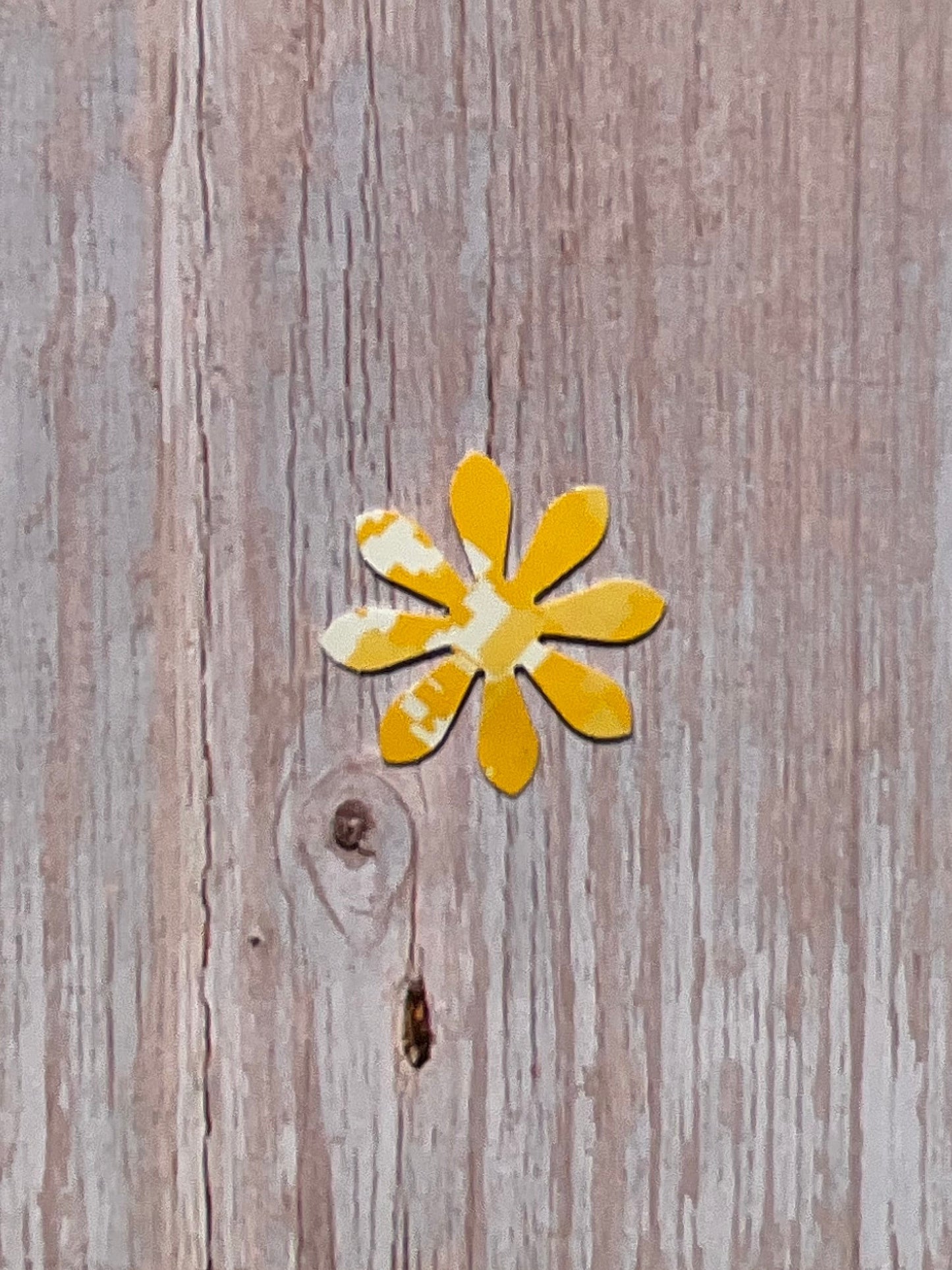 Yellow daisy flower vinyl sticker on a wooden background