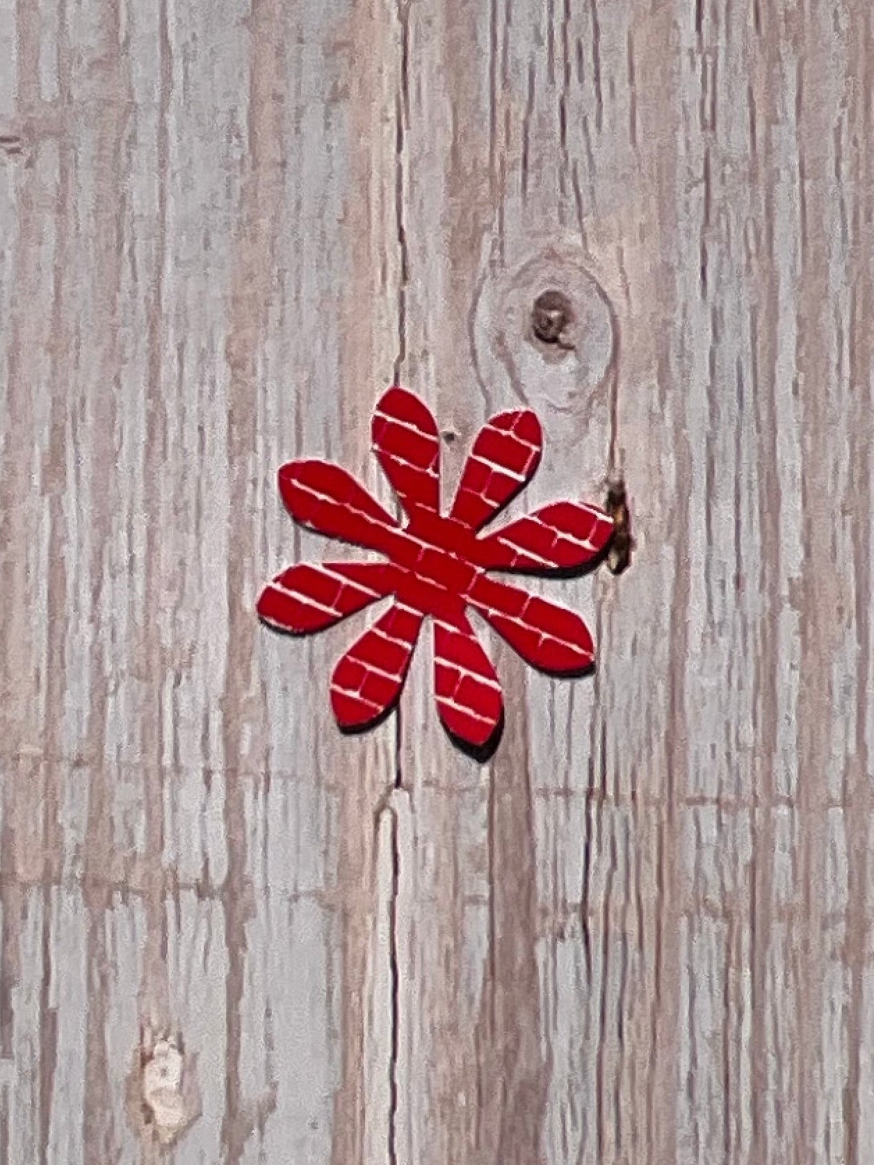 Red flower vinyl sticker design on a wooden surface